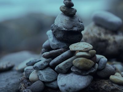 A stack of smooth stones balanced on a beach.